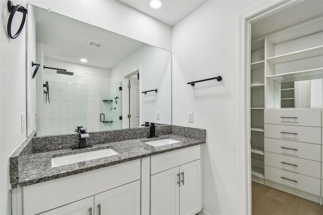 2139 Stellar Brilliance Way, Lutz, FL 33558 - full bath featuring a spacious closet, a stall shower, double vanity, wood finished floors, and recessed lighting