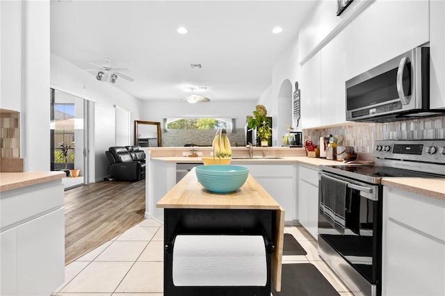 5740 Bounty Cir, Tavares, FL 32778 - kitchen featuring appliances with stainless steel finishes, backsplash, a ceiling fan, white cabinetry, and recessed lighting