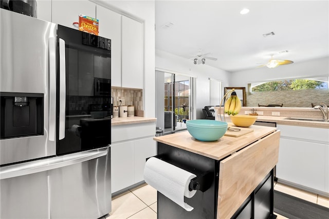 5740 Bounty Cir, Tavares, FL 32778 - kitchen featuring stainless steel fridge, backsplash, butcher block countertops, a ceiling fan, and white cabinets