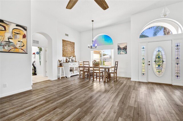 5740 Bounty Cir, Tavares, FL 32778 - foyer entrance with a high ceiling, healthy amount of natural light, arched walkways, wood finished floors, and ceiling fan