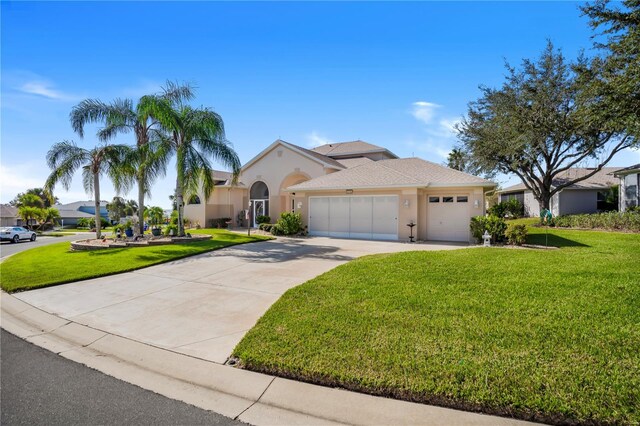 5740 Bounty Cir, Tavares, FL 32778 - view of front of house featuring stucco siding, driveway, a garage, and a front lawn