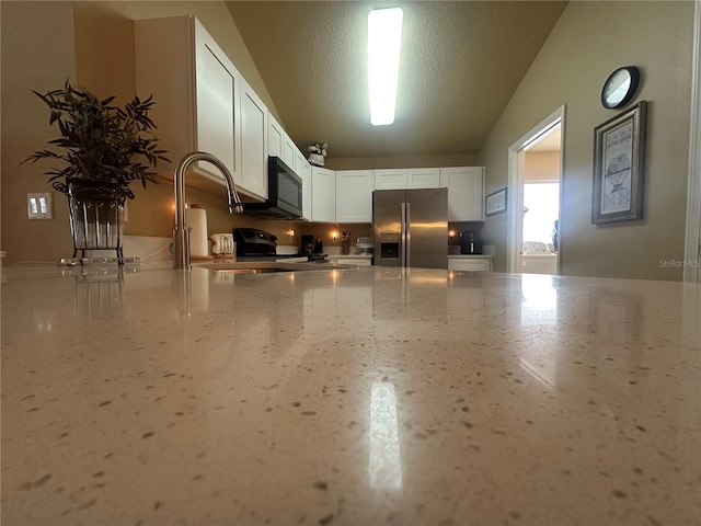 15509 Markham Dr, Clermont, FL 34714 - kitchen with stainless steel appliances, light stone countertops, white cabinetry, a textured ceiling, and a peninsula