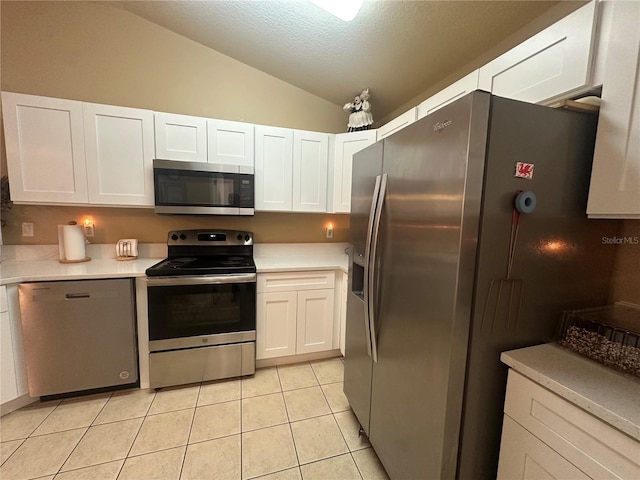 15509 Markham Dr, Clermont, FL 34714 - kitchen with appliances with stainless steel finishes, vaulted ceiling, white cabinets, light countertops, and light tile patterned flooring