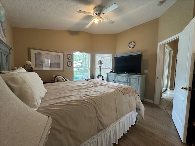 15509 Markham Dr, Clermont, FL 34714 - bedroom with wood finished floors, lofted ceiling, a ceiling fan, a textured ceiling, and access to exterior