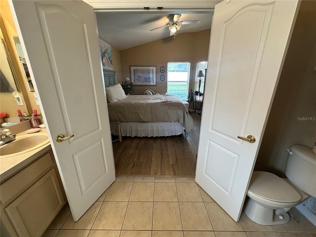 15509 Markham Dr, Clermont, FL 34714 - ensuite bathroom featuring vaulted ceiling, vanity, a ceiling fan, tile patterned flooring, and a fireplace