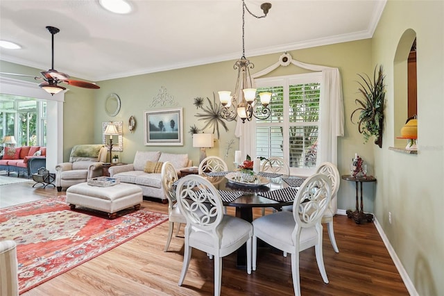 2512 Baywater Rd, Tavares, FL 32778 - dining space with arched walkways, a chandelier, wood finished floors, a ceiling fan, and crown molding