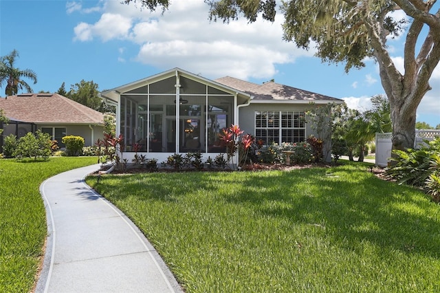 2512 Baywater Rd, Tavares, FL 32778 - rear view of house featuring a sunroom and a lawn