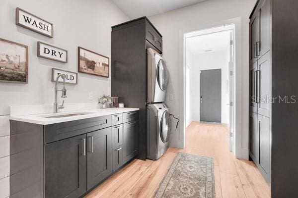 10711 County Road 561, Clermont, FL 34711 - laundry room featuring stacked washer and clothes dryer, light wood-style floors, and cabinet space