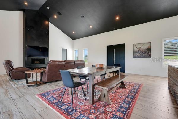 10711 County Road 561, Clermont, FL 34711 - dining area featuring healthy amount of natural light, light wood-type flooring, and high vaulted ceiling