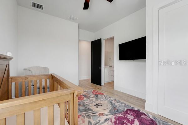 10711 County Road 561, Clermont, FL 34711 - bedroom with light wood-style flooring, a ceiling fan, and ensuite bath
