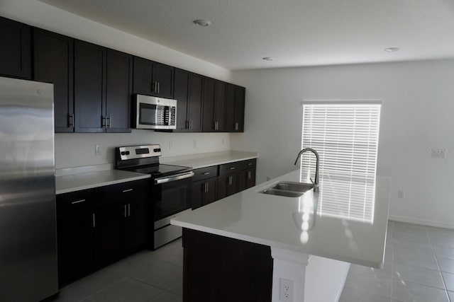 1138 Calico Pointe Cir, Groveland, FL 34736 - kitchen with stainless steel appliances, light tile patterned flooring, light countertops, a center island with sink, and recessed lighting
