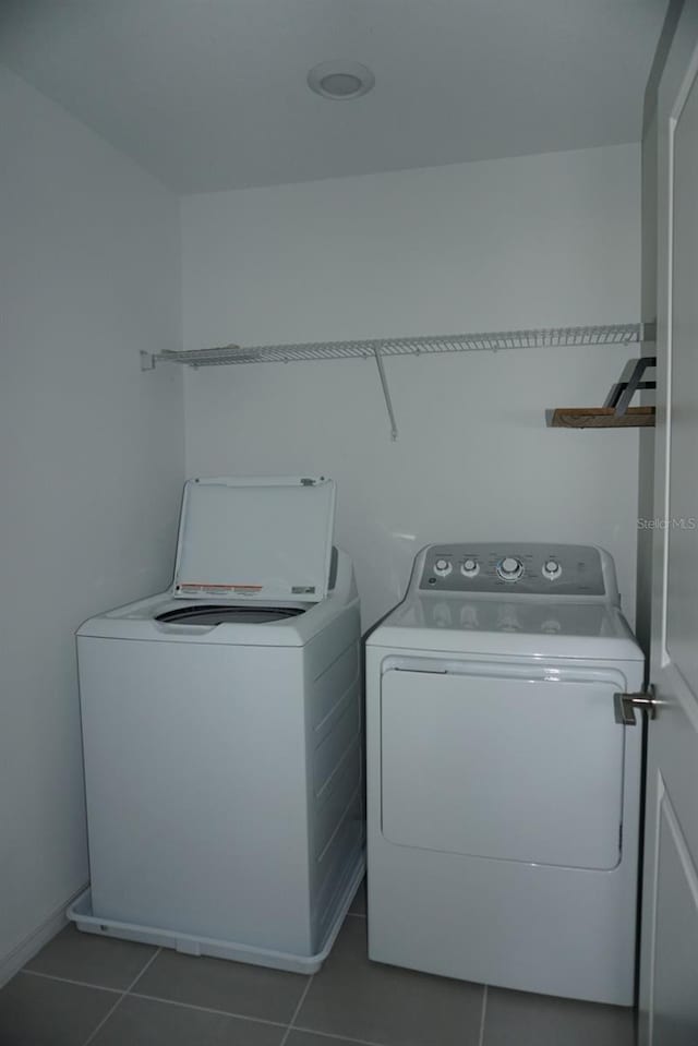 1138 Calico Pointe Cir, Groveland, FL 34736 - laundry area featuring washer and dryer and dark tile patterned flooring