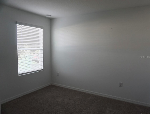 1138 Calico Pointe Cir, Groveland, FL 34736 - empty room featuring dark colored carpet and baseboards