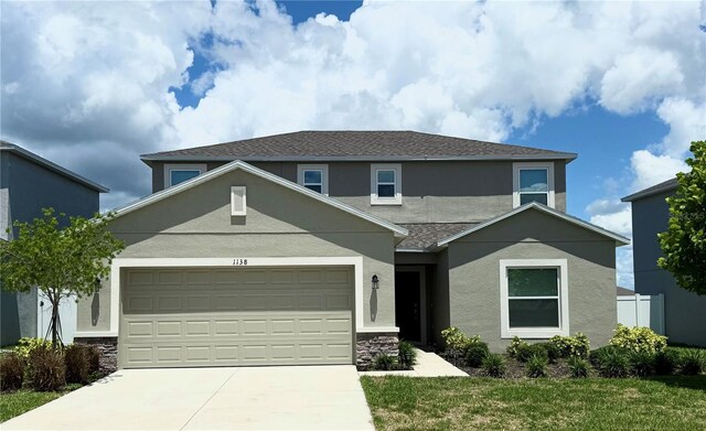 1138 Calico Pointe Cir, Groveland, FL 34736 - traditional-style home featuring stucco siding, driveway, an attached garage, and a front lawn