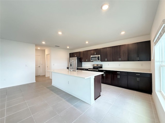 1138 Calico Pointe Cir, Groveland, FL 34736 - kitchen with stainless steel appliances, a center island with sink, recessed lighting, light countertops, and light tile patterned floors