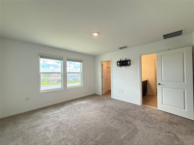 1138 Calico Pointe Cir, Groveland, FL 34736 - unfurnished bedroom with carpet floors, a spacious closet, and connected bathroom