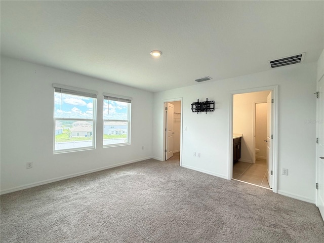 1138 Calico Pointe Cir, Groveland, FL 34736 - unfurnished bedroom with carpet floors, a walk in closet, and connected bathroom