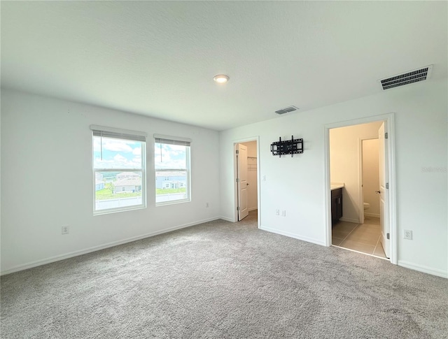 1138 Calico Pointe Cir, Groveland, FL 34736 - unfurnished bedroom with carpet, a walk in closet, and connected bathroom