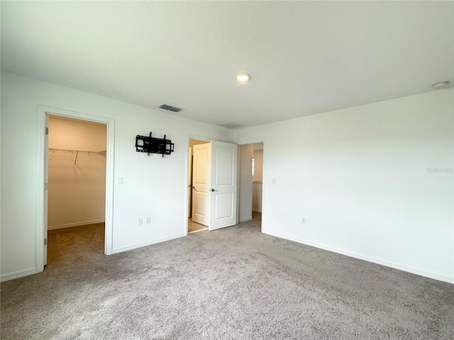 1138 Calico Pointe Cir, Groveland, FL 34736 - unfurnished bedroom featuring a walk in closet, carpet flooring, and a closet