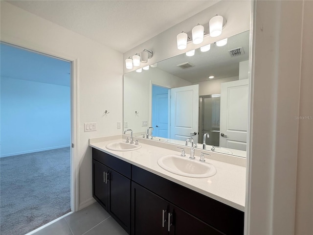 1138 Calico Pointe Cir, Groveland, FL 34736 - bathroom with double vanity, tile patterned flooring, and an enclosed shower