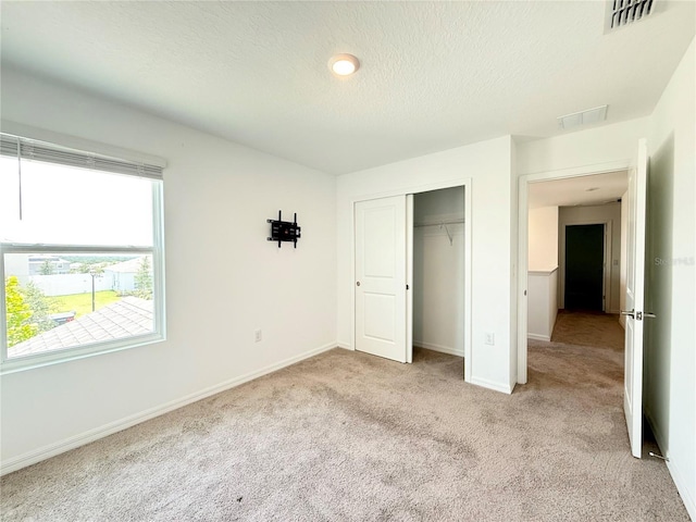 1138 Calico Pointe Cir, Groveland, FL 34736 - unfurnished bedroom with light carpet, a closet, and a textured ceiling