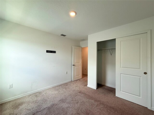 1138 Calico Pointe Cir, Groveland, FL 34736 - unfurnished bedroom with carpet floors, a closet, and a textured ceiling