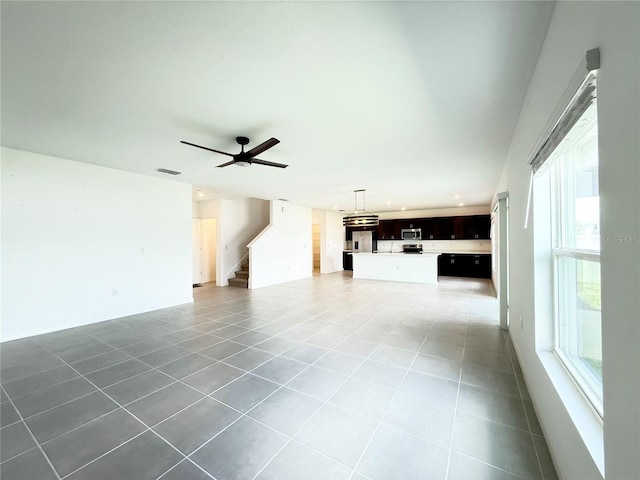 1138 Calico Pointe Cir, Groveland, FL 34736 - unfurnished living room featuring light tile patterned flooring, stairway, healthy amount of natural light, recessed lighting, and a ceiling fan
