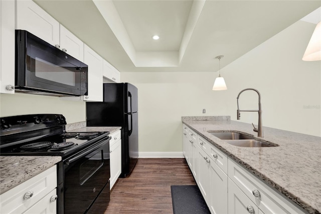 2815 Spyglass Cv, Longwood, FL 32779 - kitchen featuring black appliances, dark wood-type flooring, white cabinetry, light stone counters, and a tray ceiling