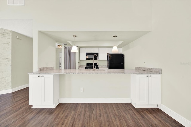 2815 Spyglass Cv, Longwood, FL 32779 - kitchen with black appliances, a peninsula, dark wood-style flooring, and light stone counters