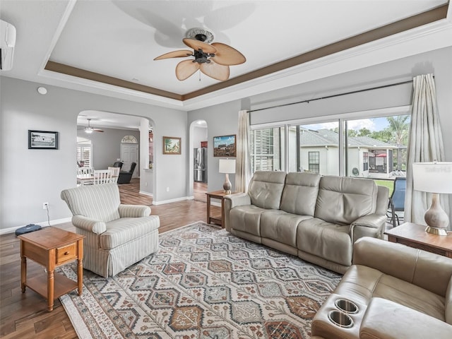 16863 SE 110th Court Rd, Summerfield, FL 34491 - living room featuring ceiling fan, arched walkways, a raised ceiling, and wood finished floors