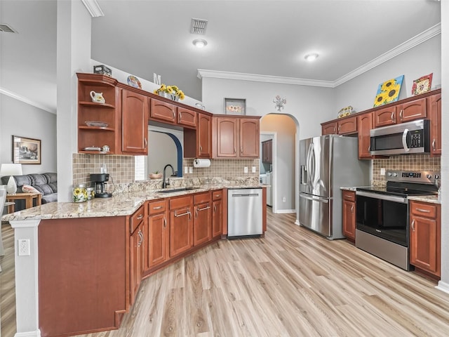 16863 SE 110th Court Rd, Summerfield, FL 34491 - kitchen featuring stainless steel appliances, ornamental molding, backsplash, light wood finished floors, and arched walkways