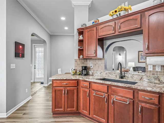 16863 SE 110th Court Rd, Summerfield, FL 34491 - kitchen with crown molding, open shelves, decorative backsplash, light stone countertops, and arched walkways
