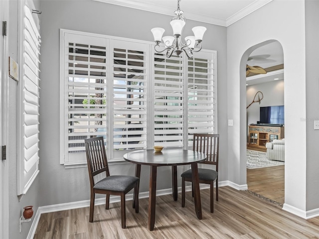 16863 SE 110th Court Rd, Summerfield, FL 34491 - dining area featuring wood finished floors, arched walkways, healthy amount of natural light, a chandelier, and ornamental molding