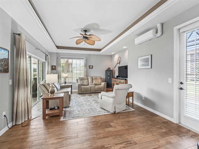 16863 SE 110th Court Rd, Summerfield, FL 34491 - living area featuring a wall unit AC, a raised ceiling, ceiling fan, wood-type flooring, and crown molding