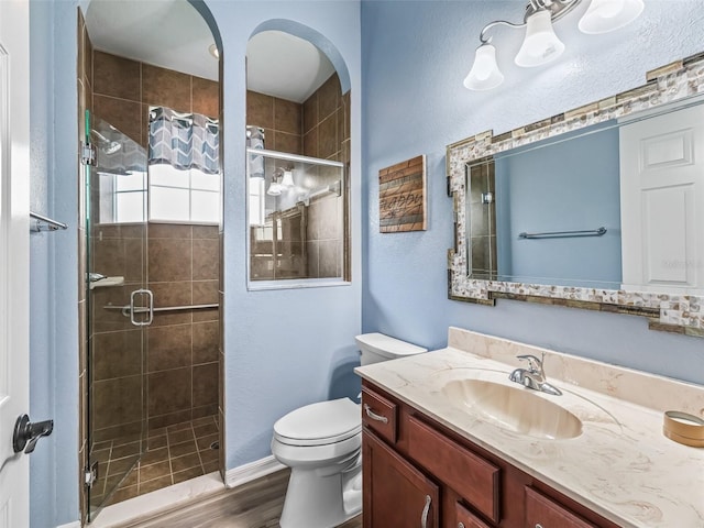 16863 SE 110th Court Rd, Summerfield, FL 34491 - bathroom featuring vanity, a shower stall, wood finished floors, and a textured wall