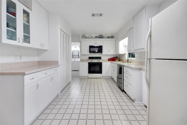 5319 Eagles Nest Rd, Fruitland Park, FL 34731 - kitchen featuring white appliances, white cabinets, light countertops, and glass insert cabinets