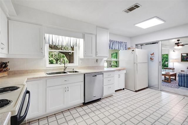 5319 Eagles Nest Rd, Fruitland Park, FL 34731 - kitchen with dishwasher, freestanding refrigerator, healthy amount of natural light, and white cabinetry
