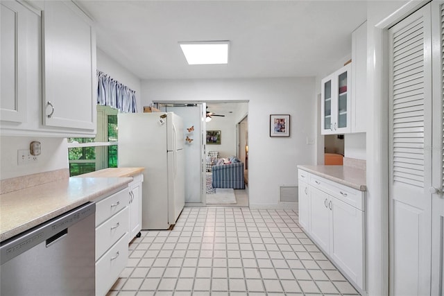 5319 Eagles Nest Rd, Fruitland Park, FL 34731 - kitchen with stainless steel dishwasher, freestanding refrigerator, white cabinets, and light countertops