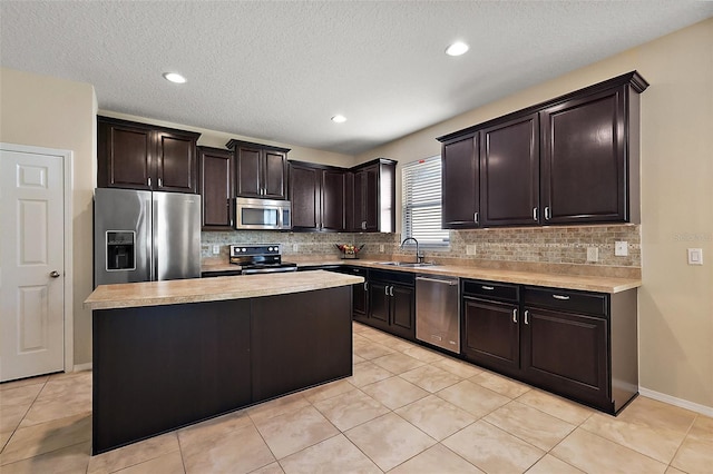 20945 Oldenburg Loop, Mount Dora, FL 32757 - kitchen with stainless steel appliances, light countertops, decorative backsplash, a center island, and a textured ceiling