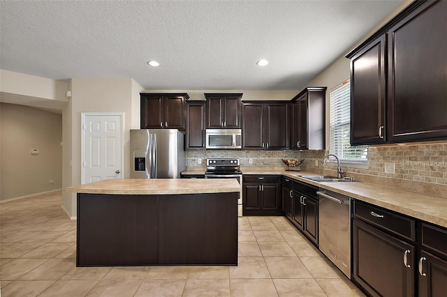 20945 Oldenburg Loop, Mount Dora, FL 32757 - kitchen with appliances with stainless steel finishes, decorative backsplash, light tile patterned floors, a center island, and a textured ceiling