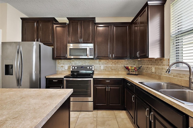 20945 Oldenburg Loop, Mount Dora, FL 32757 - kitchen featuring appliances with stainless steel finishes, light tile patterned floors, light countertops, backsplash, and a textured ceiling