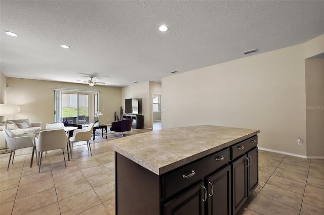 20945 Oldenburg Loop, Mount Dora, FL 32757 - kitchen featuring open floor plan, light tile patterned flooring, a textured ceiling, a ceiling fan, and a center island
