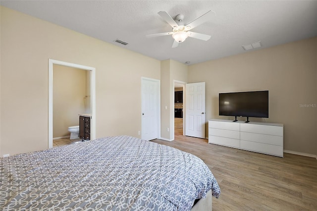 20945 Oldenburg Loop, Mount Dora, FL 32757 - bedroom with wood finished floors, ensuite bath, and a ceiling fan