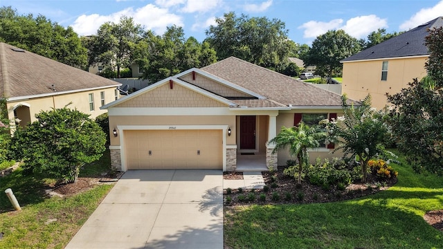 20945 Oldenburg Loop, Mount Dora, FL 32757 - craftsman-style home featuring concrete driveway, an attached garage, stone siding, a front yard, and roof with shingles