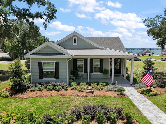 622 W 11th Ave, Mount Dora, FL 32757 - view of front of house with covered porch, a shingled roof, a front lawn, and a standing seam roof