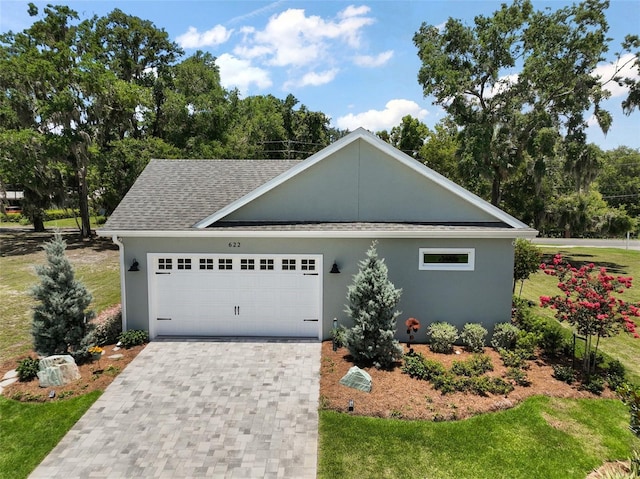 622 W 11th Ave, Mount Dora, FL 32757 - view of front of home featuring stucco siding, a shingled roof, a garage, driveway, and a front lawn