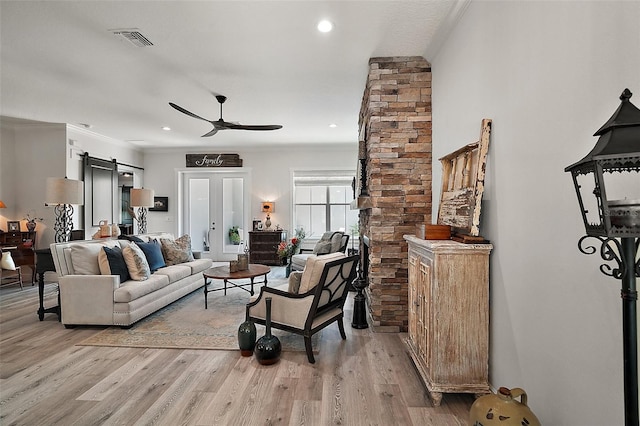 622 W 11th Ave, Mount Dora, FL 32757 - living room featuring a barn door, ceiling fan, ornamental molding, light wood-type flooring, and recessed lighting