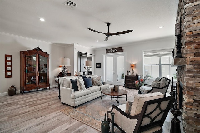 622 W 11th Ave, Mount Dora, FL 32757 - living area featuring a large fireplace, ceiling fan, a barn door, light wood-style flooring, and recessed lighting