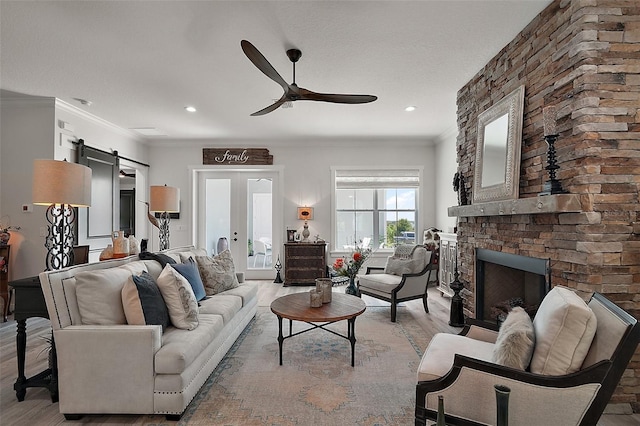 622 W 11th Ave, Mount Dora, FL 32757 - living room with ceiling fan, light wood finished floors, a brick fireplace, recessed lighting, and a barn door