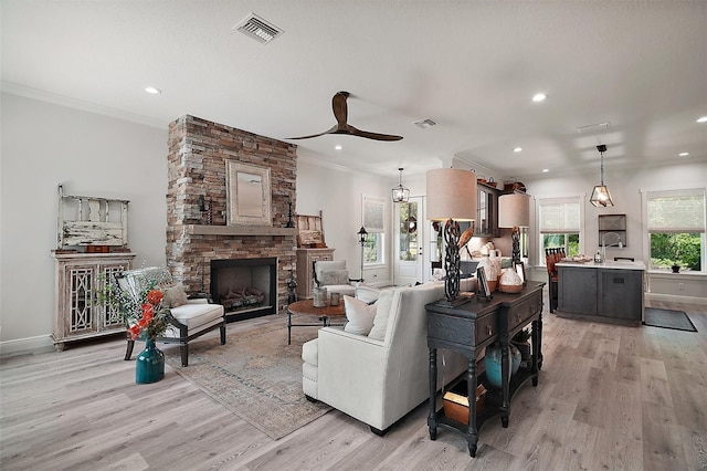 622 W 11th Ave, Mount Dora, FL 32757 - living room with light wood-type flooring, ornamental molding, a fireplace, recessed lighting, and ceiling fan